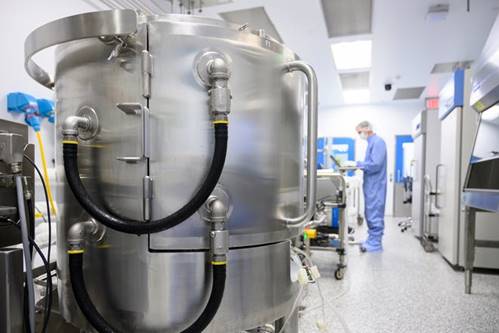 A Lonza Biologics employee in Portsmouth enters data on the other side of a mixer used in the production of the mRNA-1273 vaccine Moderna developed to fight the COVID-19 virus.