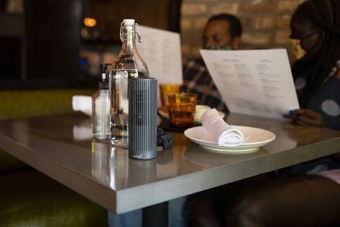A portable ionic air purifier is seen Sept. 17, 2020, on a table at Formento's, an Italian restaurant in Chicago's West Town neighborhood. Recently, Formento's installed an array of air filtration and ventilation devices to help diners feel safe eating inside the restaurant.